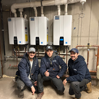 3R plumbing techs in front of 3 tankless water heaters installed